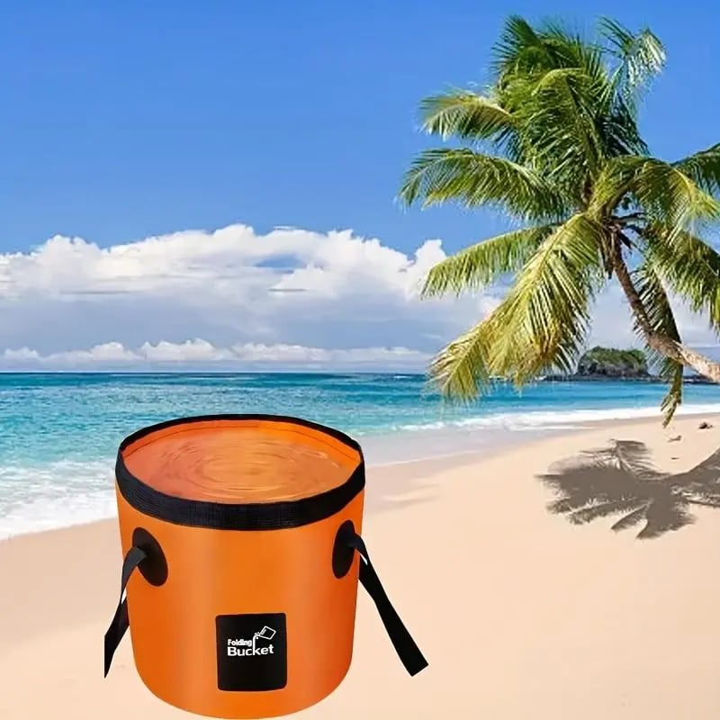 Portable orange folding bucket on a tropical beach