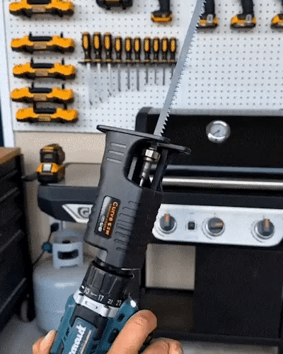 Drill-powered reciprocating saw attachment in use