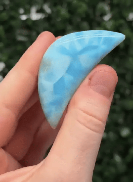 Close-up of a polished blue crescent-shaped stone