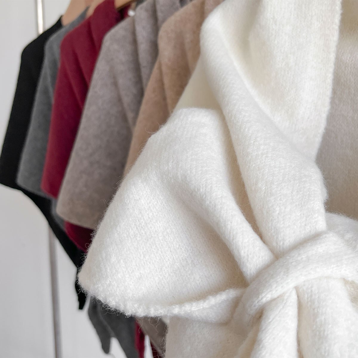 Close view of the white shawl's brushed knit texture and soft folds