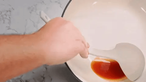 Heat-resistant silicone ladle used during stovetop cooking